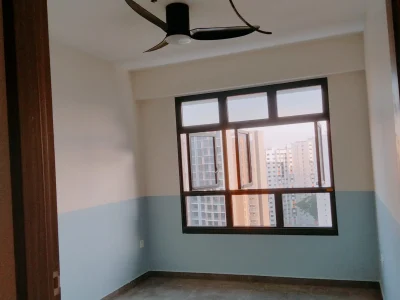 A freshly painted modern condo room featuring a two-tone blue and white wall, a black ceiling fan, and large framed windows overlooking city high-rises.