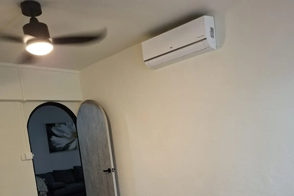 Freshly painted cream-colored room featuring an arched doorway, light wood door, wall-mounted air conditioner, and black ceiling fan.