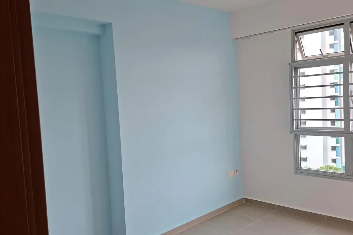An empty room featuring a light blue feature wall, smooth white Interior Painting adjoining walls, tile flooring, and a large window with grilles.
